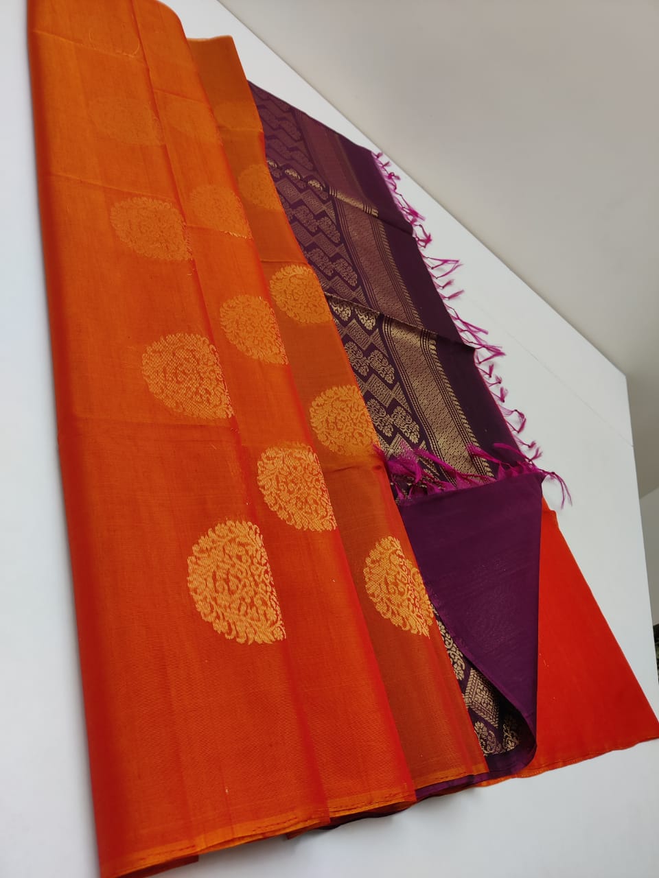 Cotton silk pure borderless in orange with maroon body color with golden butti